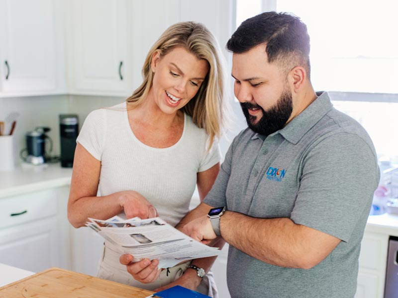 Dixon Painting team member discussing brochure with a client in her Atlanta home