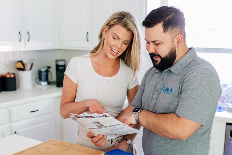 Dixon Painting team member discussing brochure with a client in her Atlanta home